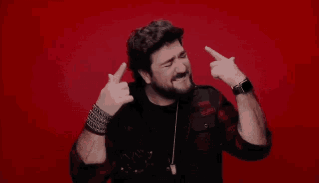 a man with a beard is wearing a watch and making a funny face .