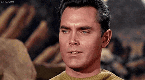 a close up of a man 's face with a yellow sweater on .