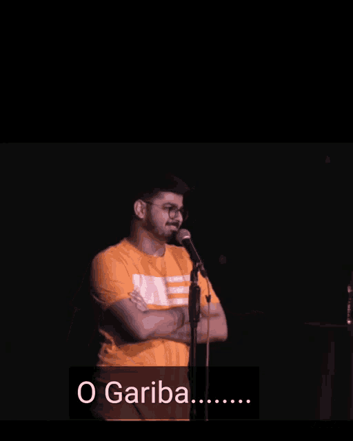 a man stands in front of a microphone with the words o gariba written below him