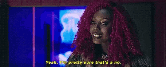 a woman with pink hair is talking to someone in a room .