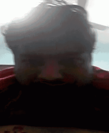 a close up of a man 's face with the sun shining on his head