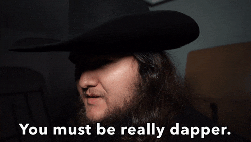 a man with long hair and a beard wearing a cowboy hat says you must be really dapper