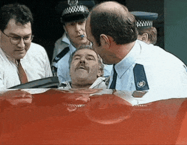 a group of police officers are standing around a man in a car