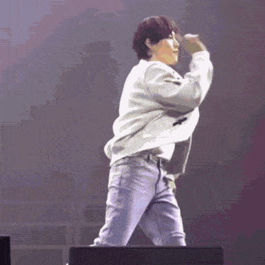 a man is dancing on a stage with a microphone in his hand .