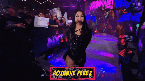 a woman stands in front of a sign that says nxt