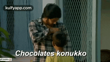 a man is putting chocolates on a child 's head and the child is saying chocolates konukku .