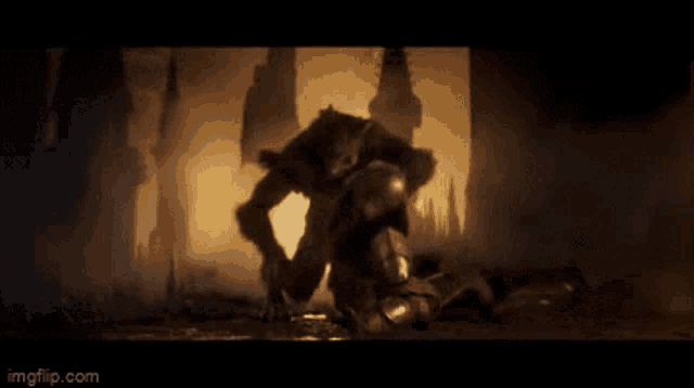 a monster is crawling on top of a person in a dark room .