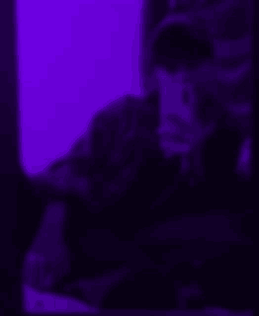 a blurry picture of a person in a dark room with purple lights .
