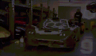 a silver sports car is parked in a garage next to a man .