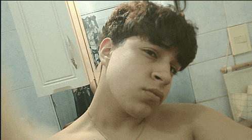 a young man takes a selfie in a bathroom