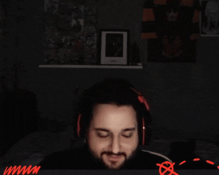 a man is covering his face with his hands in a dark room .