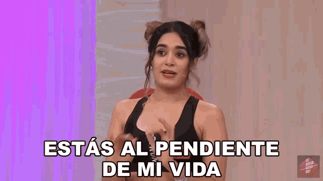 a woman says " estas al pendiente de mi vida " in front of a pink curtain