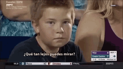 a young boy is watching a baseball game and says " qué tan lejos puedes mirar "