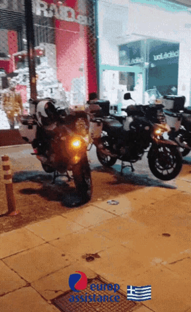 several motorcycles are parked on a sidewalk in front of a store that says ' euro assistance ' on the bottom