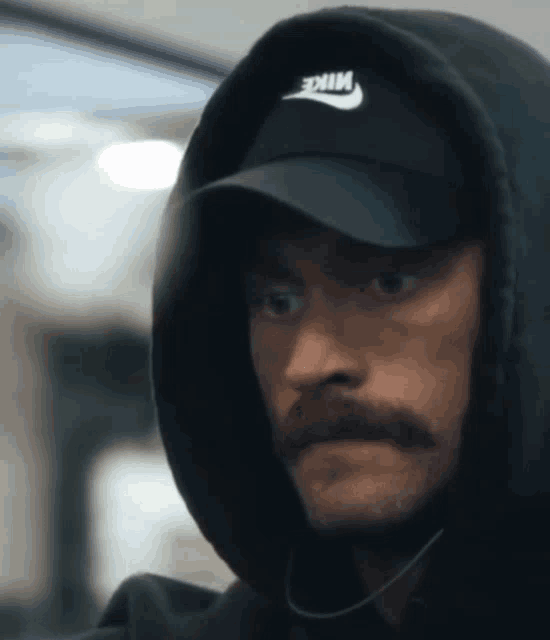 a man wearing a nike hat and a hoodie