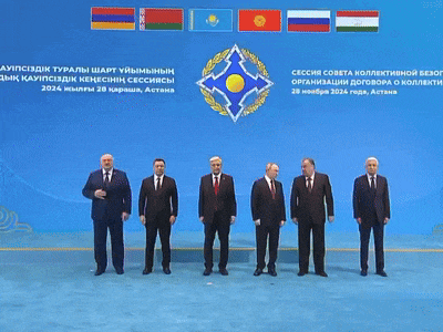 a group of men are standing in front of a sign that says ' astana ' on it