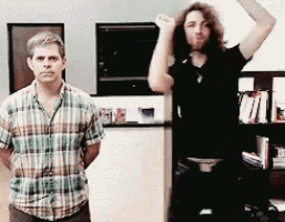 a man in a plaid shirt is standing next to a man with long hair