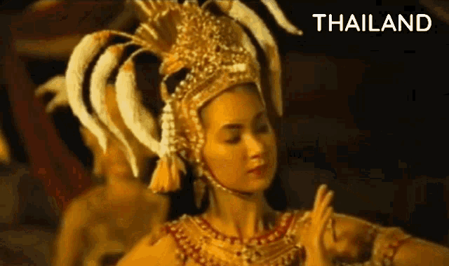 a woman in a traditional costume is dancing in front of the word thailand