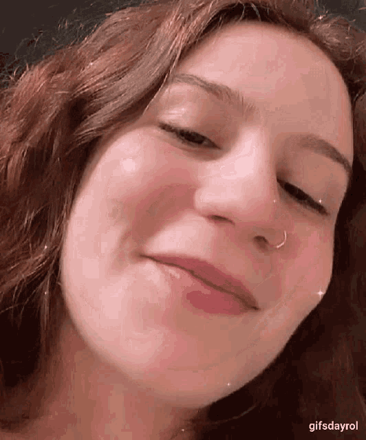 a close up of a woman 's face with a nose ring and a nose ring .