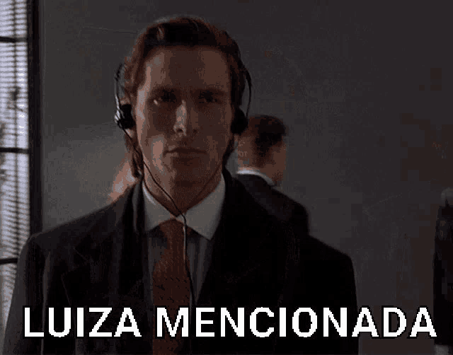 a man in a suit and tie is wearing headphones and says luiza mencionado