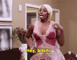 a woman in a red and white dress is standing in a living room and saying hey bitch !