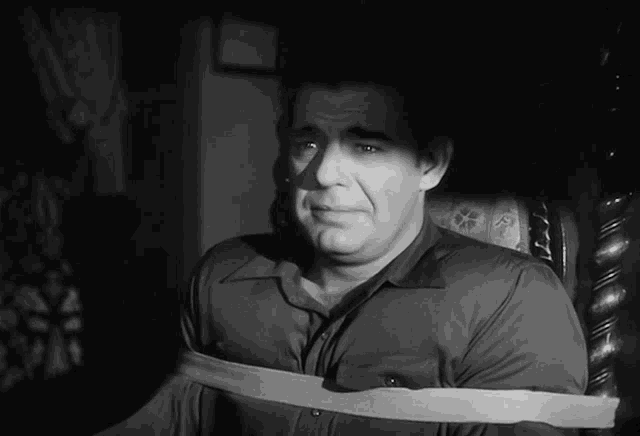 a black and white photo of a man with a tape around his neck