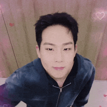 a close up of a man 's face with pink hearts behind him
