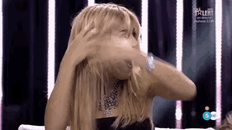 a woman covering her face with her hands on a television screen with talent on it