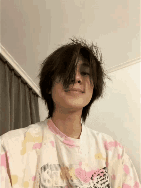 a young man wearing a tie dye shirt that says ' self ' on it