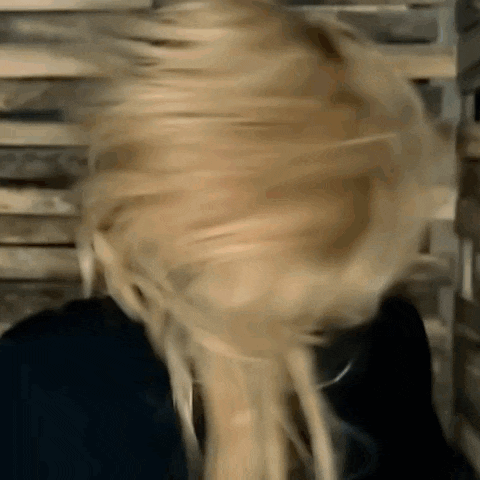 a woman with blonde hair is making a funny face while wearing a black shirt .