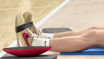 a person wearing a pair of nike shoes laying on a balance board