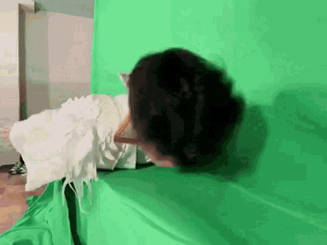 a woman in a white angel costume is laying on a green couch .