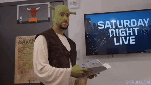 a man dressed as shrek stands in front of a saturday night live tv