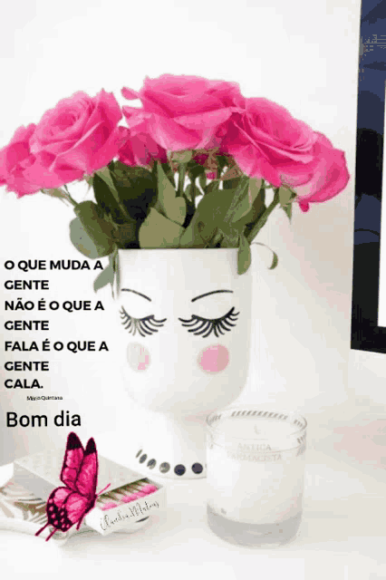 a vase of pink roses is next to a candle and a butterfly