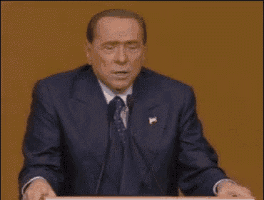 a man in a suit and tie is standing at a podium .