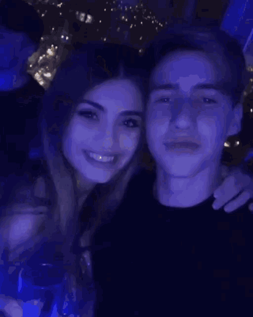 a boy and a girl are posing for a picture together