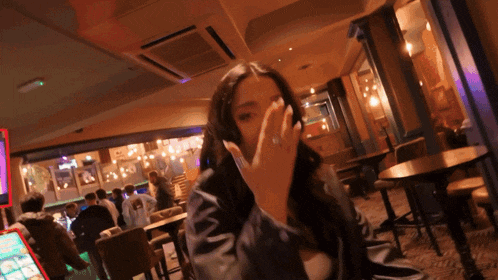 a woman covering her face with her hand in a crowded room