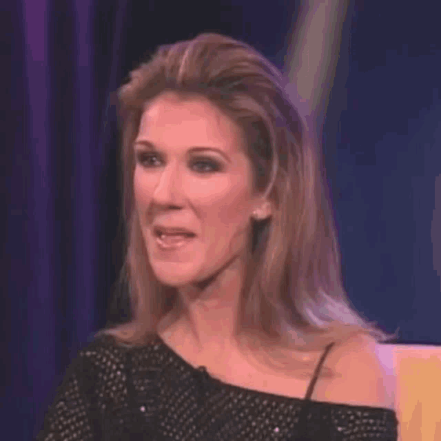 a close up of a woman 's face with a purple background and a purple curtain behind her .