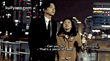 a man in a suit and tie is standing next to a woman in a coat .