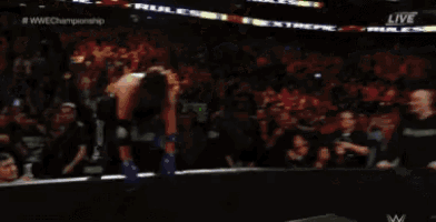 a man is laying on the ground during a wrestling match on a television screen .