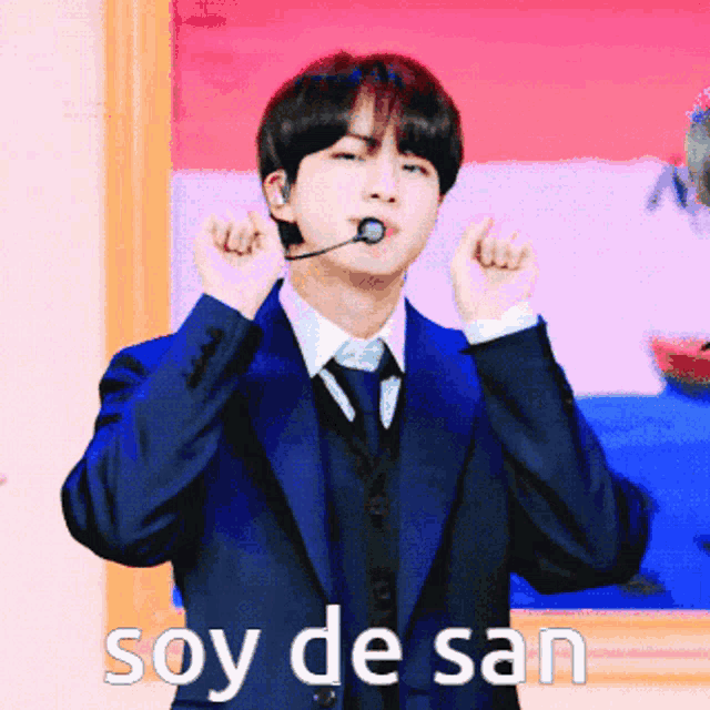 a man in a suit and tie with a microphone in his mouth and the words soy de san below him