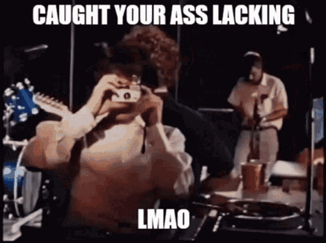 a man taking a picture of a band with the caption caught your ass lacking