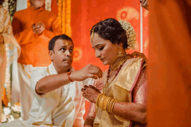 a man is putting something on a woman 's necklace