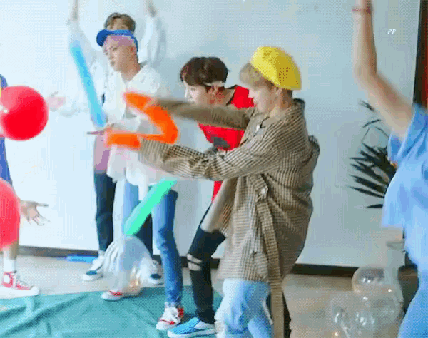 a group of people are playing with balloons in a room