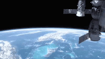 a satellite is flying over the earth in space .