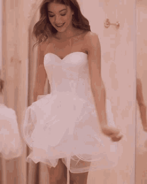 the back of a woman in a white dress is shown