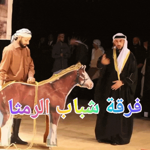 two men standing next to a cardboard horse with arabic writing