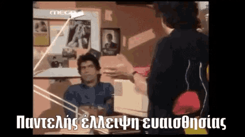 a man in a blue shirt is talking to another man in a black shirt who is holding a red purse