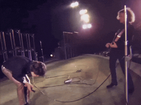 a man kneeling down on a stage with a microphone in front of him