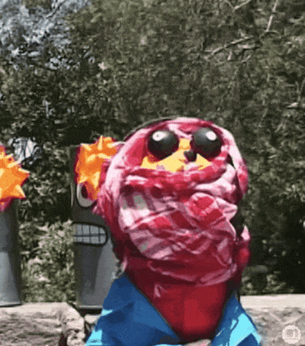 a stuffed animal wearing sunglasses and a scarf around its face .